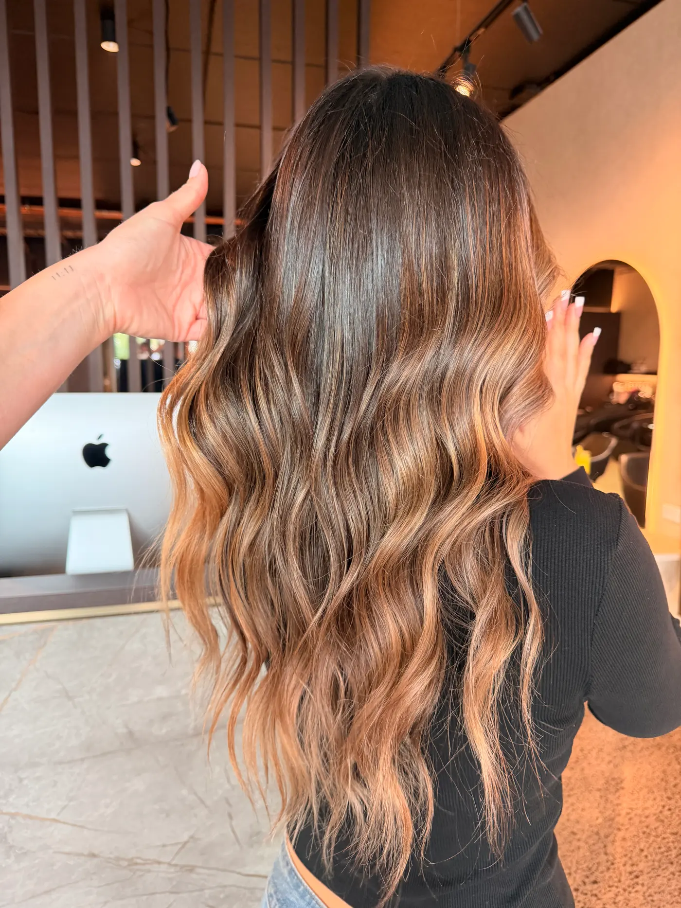 Caramel balayage painted through long dark brunette waves