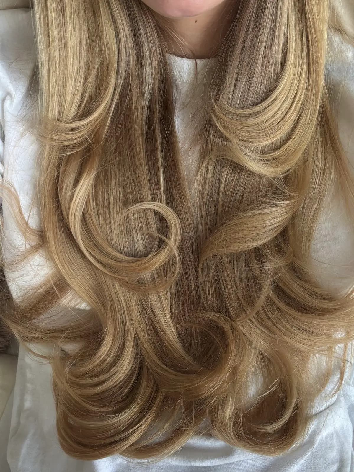 Freshly toned golden blonde lengths with soft curls after a toner and blow-dry at Jenna Ellen Hair