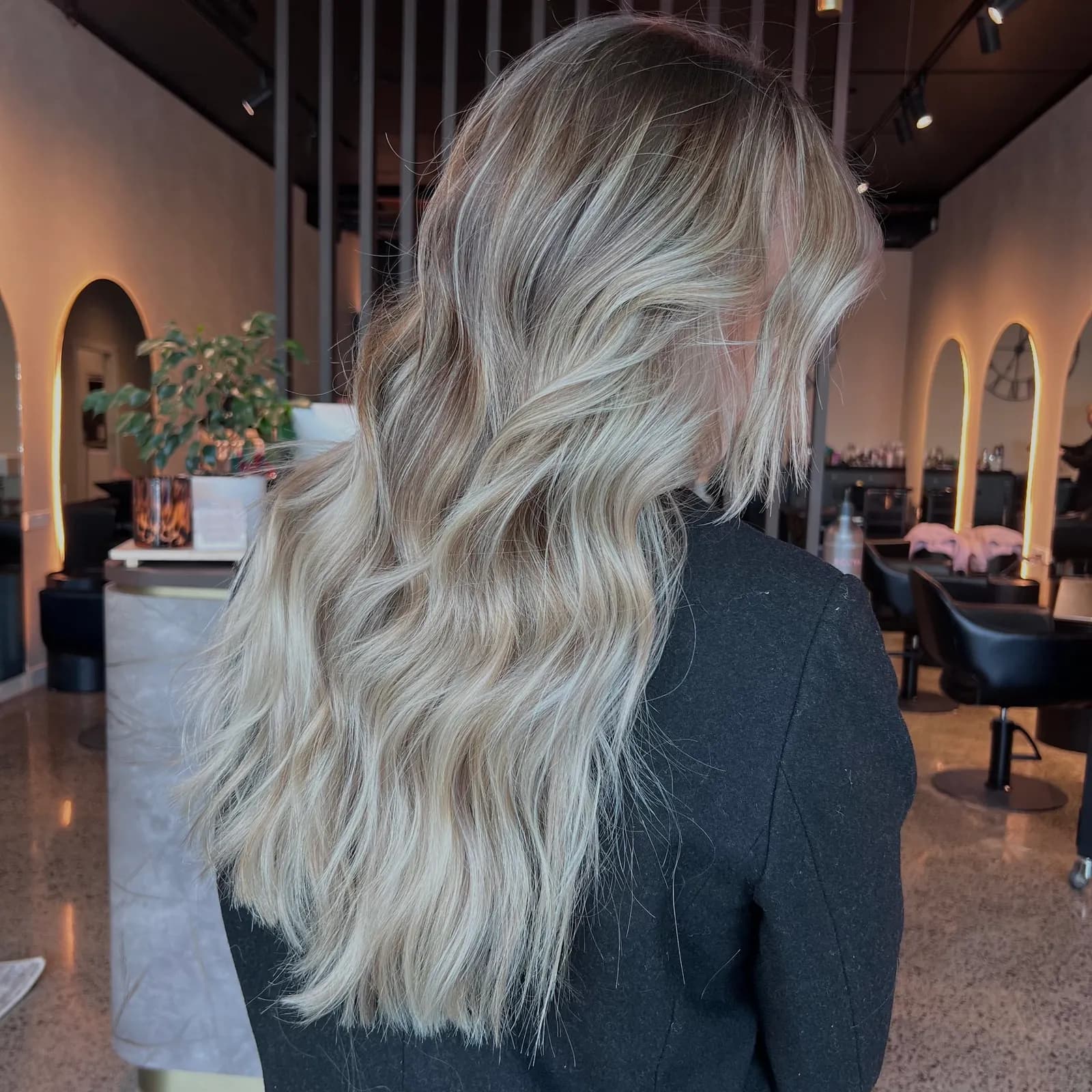 Long lived-in blonde waves with a soft root shadow