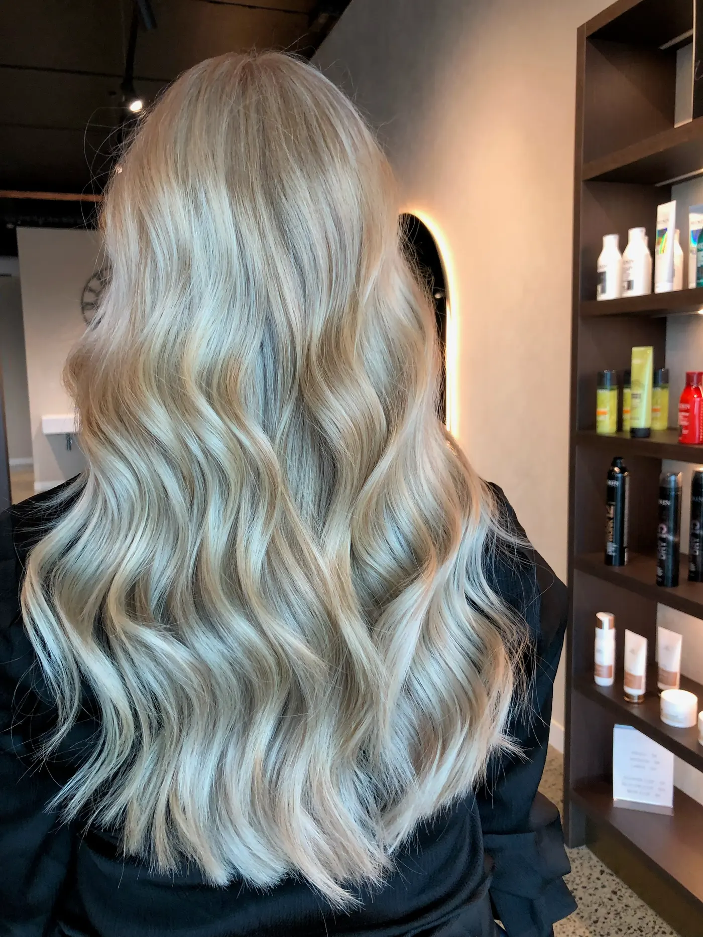 Long platinum blonde waves beside the retail shelves