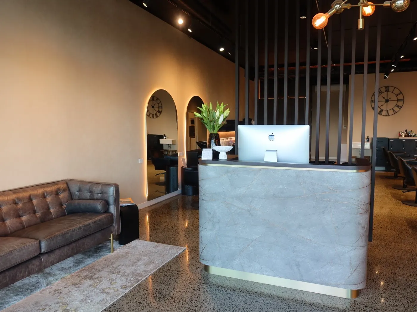The leather lounge and arched mirrors inside the salon